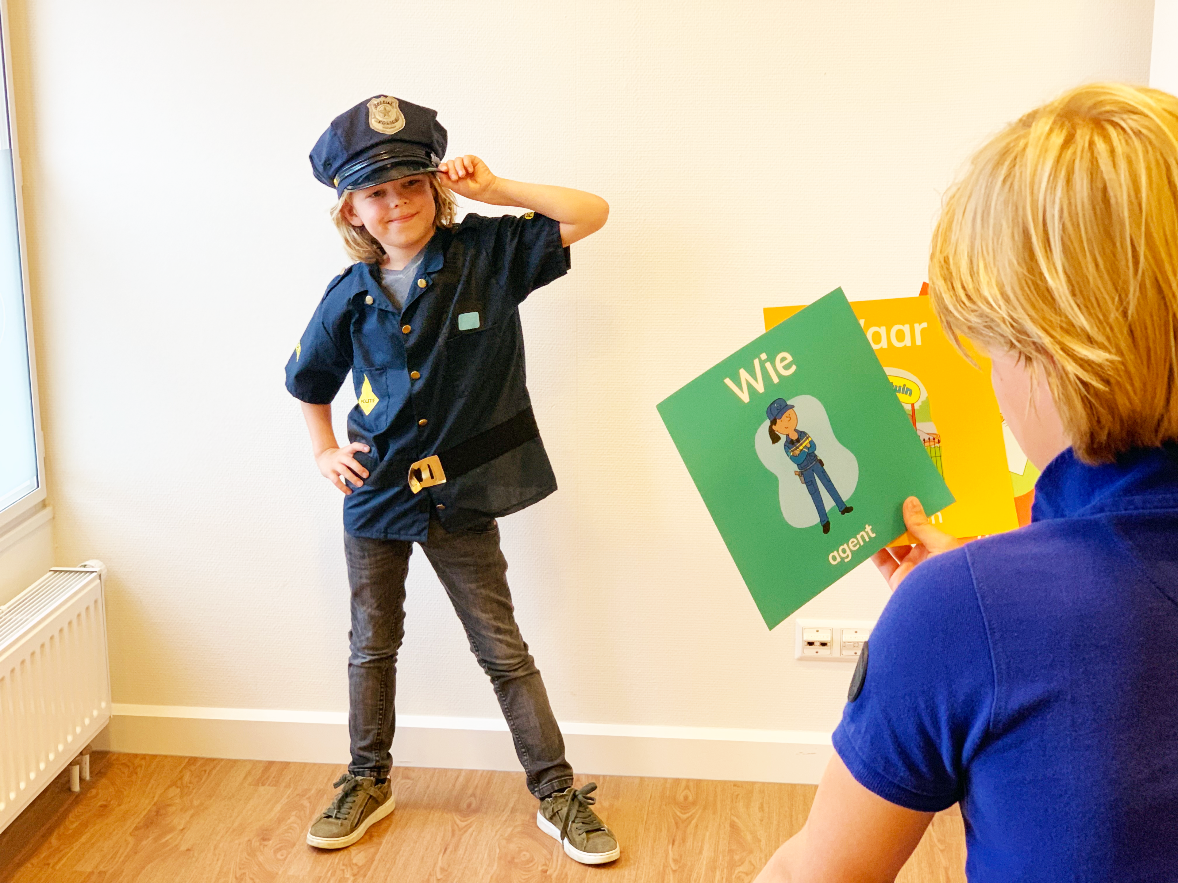 kind in politie pak tegenover ander kind met topdrama kaarten in de hand